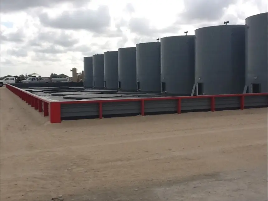 Secondary containment structure with rows of storage tanks and access catwalk