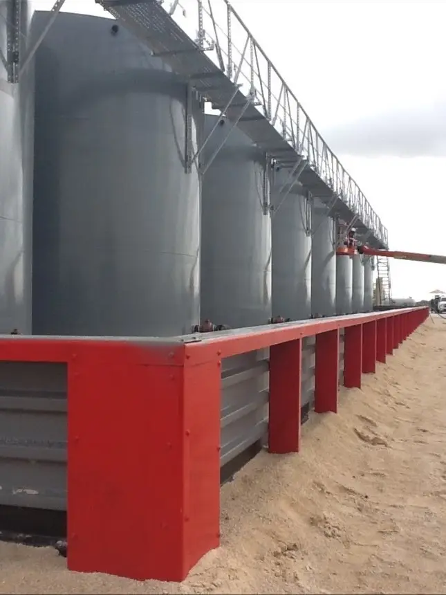 Finished containment structure with tank foundation pads and steel walls
